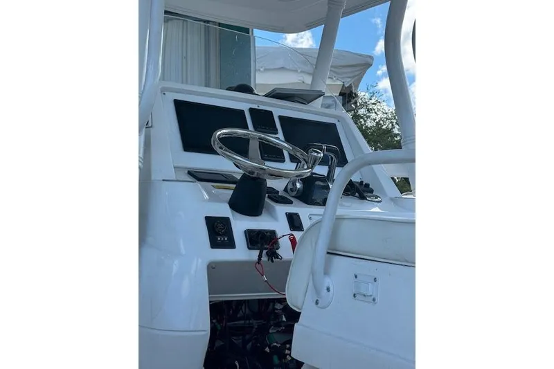 Slide: The Image of 2014 Intrepid 327 Center Console boat dashboard with steering wheel and controls. - 2