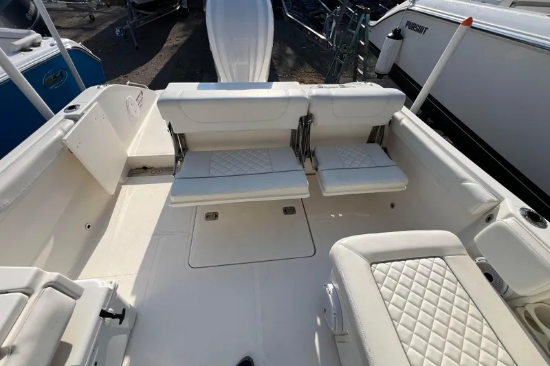 Slide: The Image of 2024 Pursuit DC 246 Dual Console boat interior with white cushioned seating. - 16
