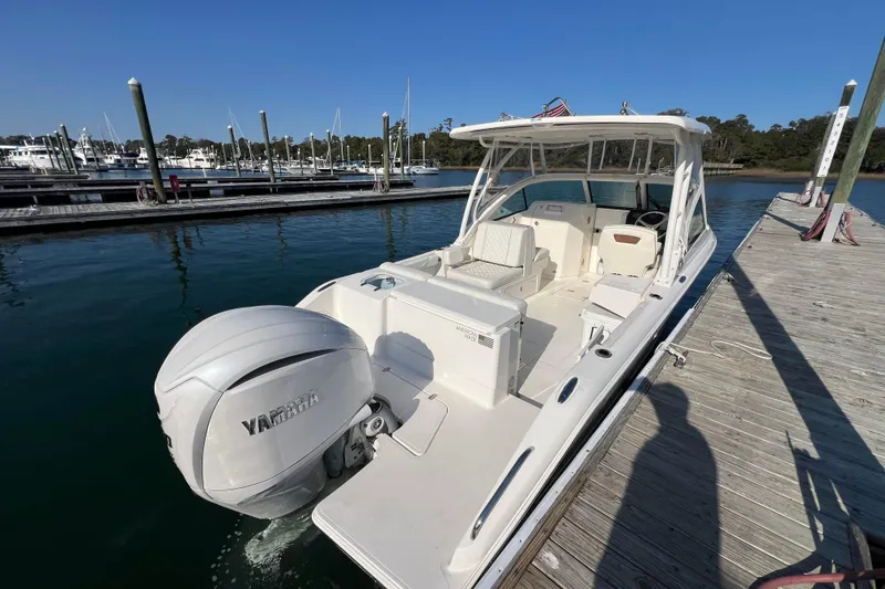 Slide: The Image of 2024 Pursuit DC 246 Dual Console boat docked with Yamaha outboard engine. - 5