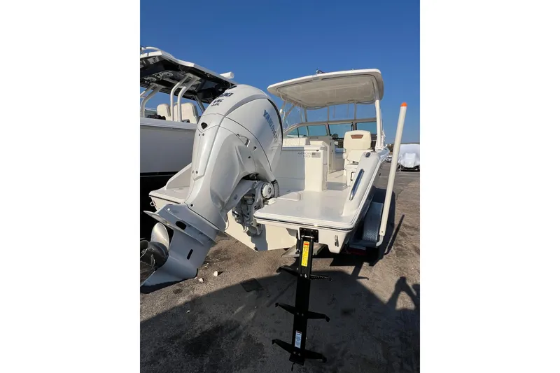 Slide: The Image of 2024 Pursuit DC 246 Dual Console boat with Yamaha outboard motor, docked on a sunny day. - 9