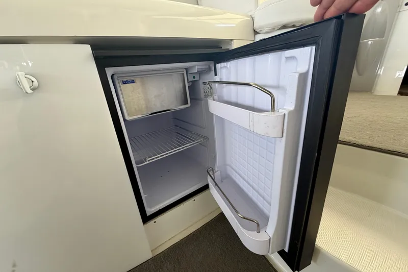 Slide: The Image of Open mini fridge on 2002 Formula 37 Performance Cruiser boat, showing interior shelves. - 15