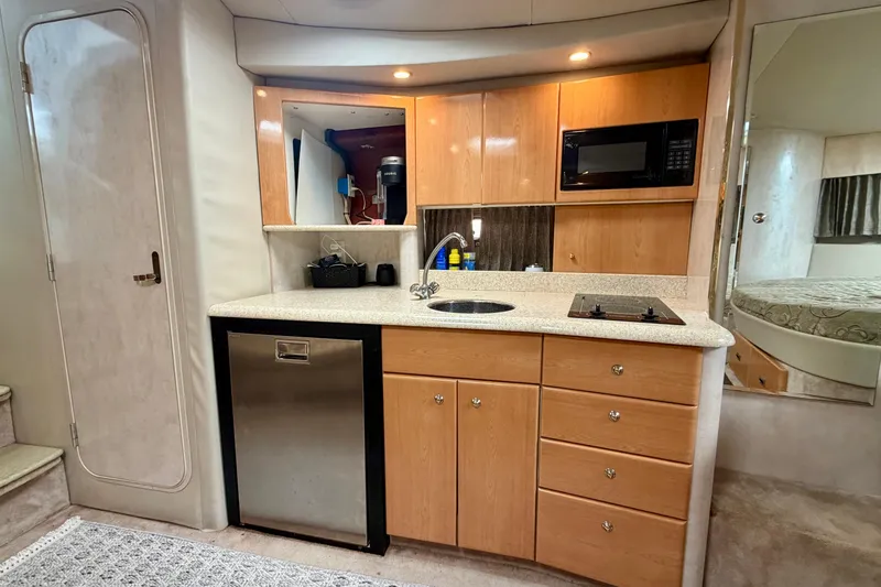Slide: The Image of Interior of 2002 Formula 37 Performance Cruiser with kitchenette, featuring wood cabinets and modern appliances. - 27