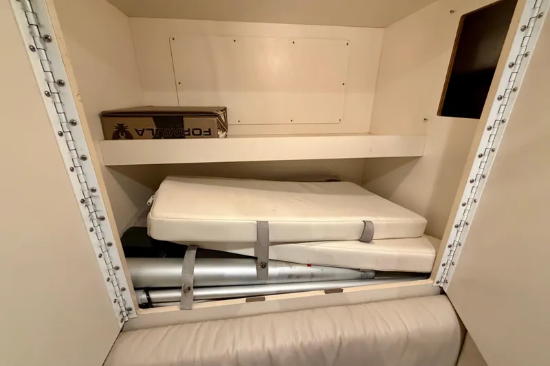 Slide: The Image of Storage compartment in a 2002 Formula 37 Performance Cruiser with cushions and a box. - 33