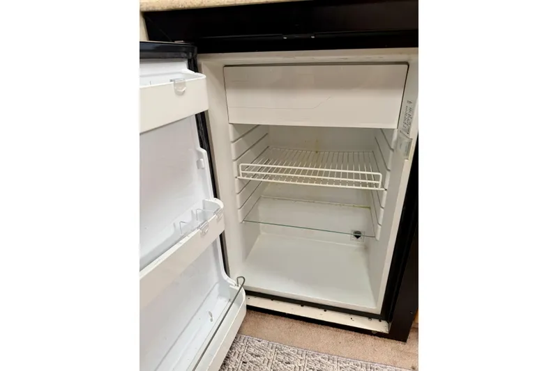 Slide: The Image of Open refrigerator inside a 2002 Formula 37 Performance Cruiser, showing empty shelves. - 36