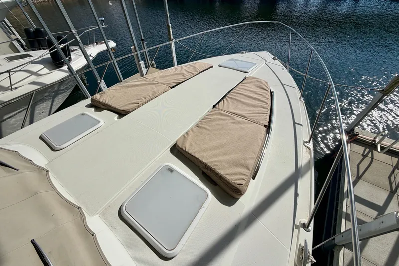 Slide: The Image of 2002 Formula 37 Performance Cruiser deck with sun pads and hatches, docked by water. - 7