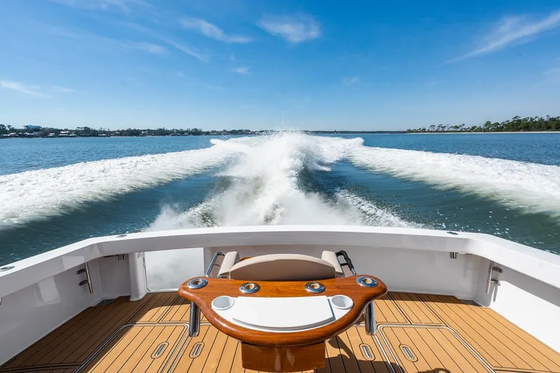 Slide: The Image of 2002 Viking 61 Convertible yacht cruising on open water, leaving a wake behind. - 16