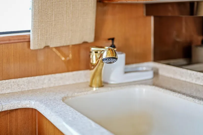 Slide: The Image of Luxury kitchen sink with gold faucet in 2002 Viking 61 Convertible yacht. - 27