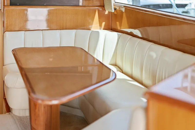 Slide: The Image of Luxurious interior of 2002 Viking 61 Convertible yacht with elegant seating and wooden table. - 32