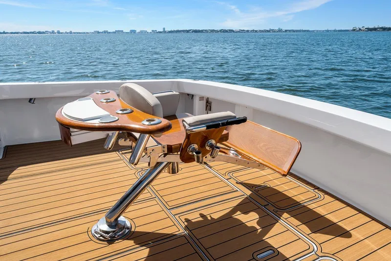 Slide: The Image of 2002 Viking 61 Convertible yacht deck with fishing chair, overlooking calm ocean waters. - 33