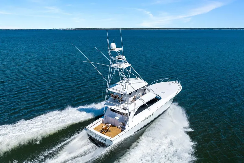 Slide: The Image of 2002 Viking 61 Convertible yacht cruising on open blue waters. - 4