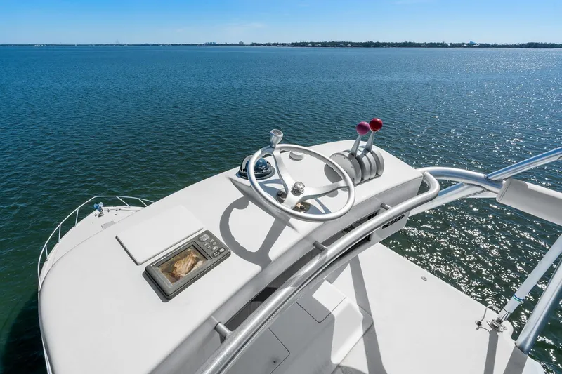 Slide: The Image of 2002 Viking 61 Convertible yacht helm overlooking calm blue waters. - 40