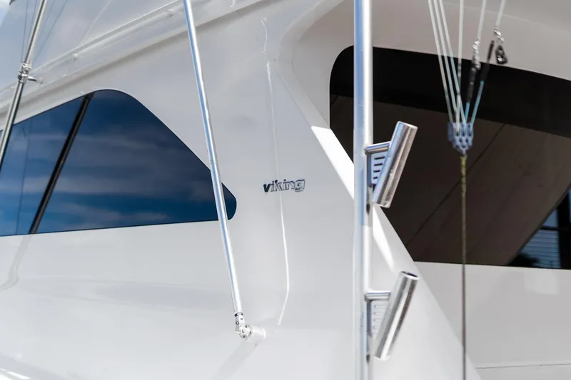 Slide: The Image of Close-up of a 2002 Viking 61 Convertible yacht exterior with logo and windows. - 43