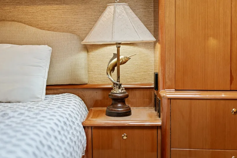 Slide: The Image of Luxurious 2002 Viking 61 Convertible yacht interior with elegant lamp and wooden cabinetry. - 48