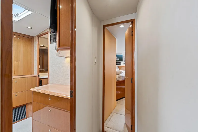 Slide: The Image of Interior of 2002 Viking 61 Convertible yacht, featuring wooden cabinetry and cozy bedroom. - 51