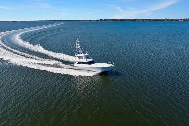 Slide: The Image of 2002 Viking 61 Convertible yacht cruising on open water, leaving a wake trail. - 6