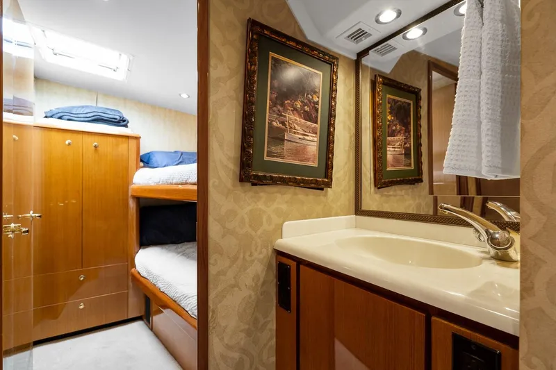Slide: The Image of Luxurious 2002 Viking 61 Convertible yacht interior with elegant bathroom and cozy bunk beds. - 60