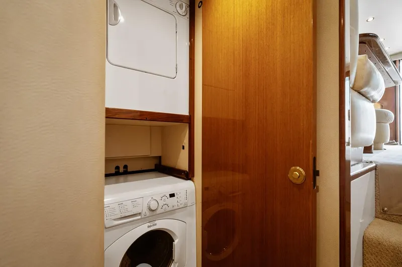 Slide: The Image of Laundry area in 2002 Viking 61 Convertible yacht with stacked washer and dryer. - 62
