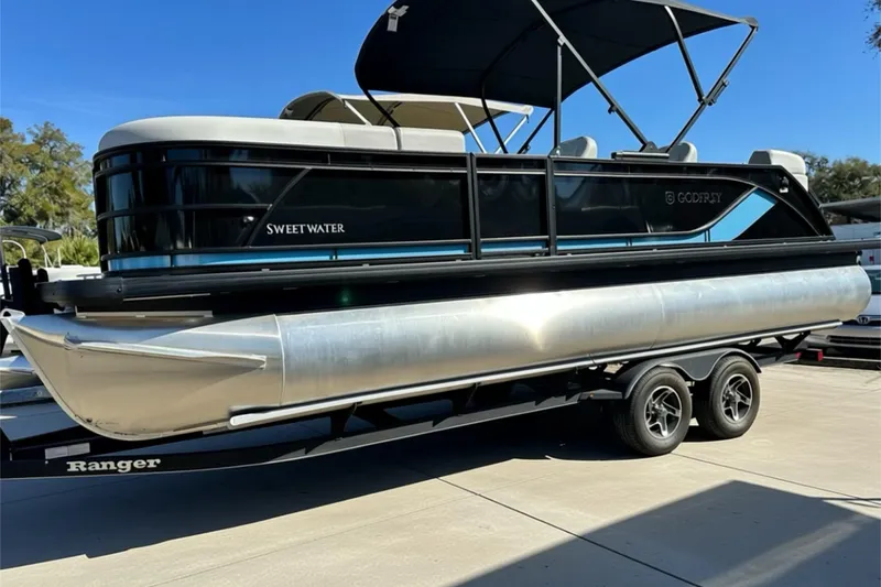 Slide: The Image of 2026 Sweetwater 2286 QS pontoon boat with Suzuki outboard motor on trailer. - 1