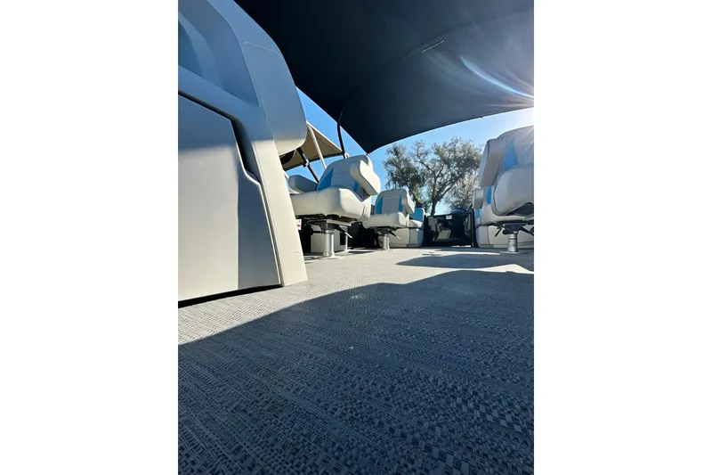 Slide: The Image of 2026 Sweetwater 2286 QS boat interior with seating and canopy, under bright sunlight. - 20
