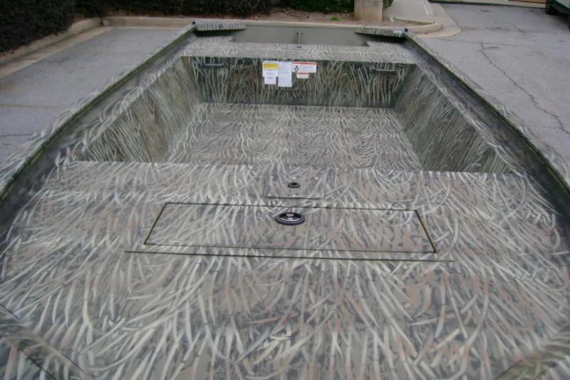 Slide: The Image of 2026 Tracker Grizzly 1648 Utility boat with camouflage design in a parking lot. - 6