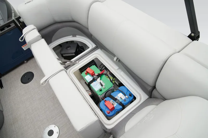 Slide: The Image of 2026 Regency 230 DL boat battery compartment under cushioned seating. - 18
