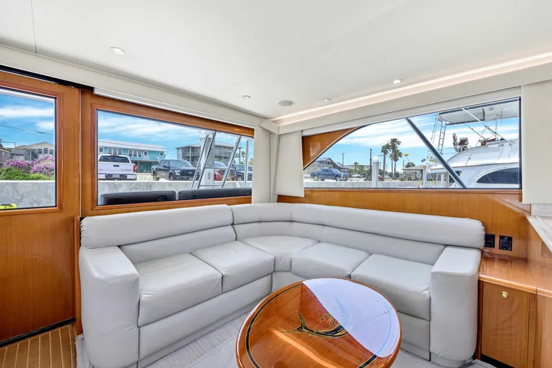 Slide: The Image of Interior of 2001 Viking 55 Convertible yacht with gray leather seating and wooden accents. - 16