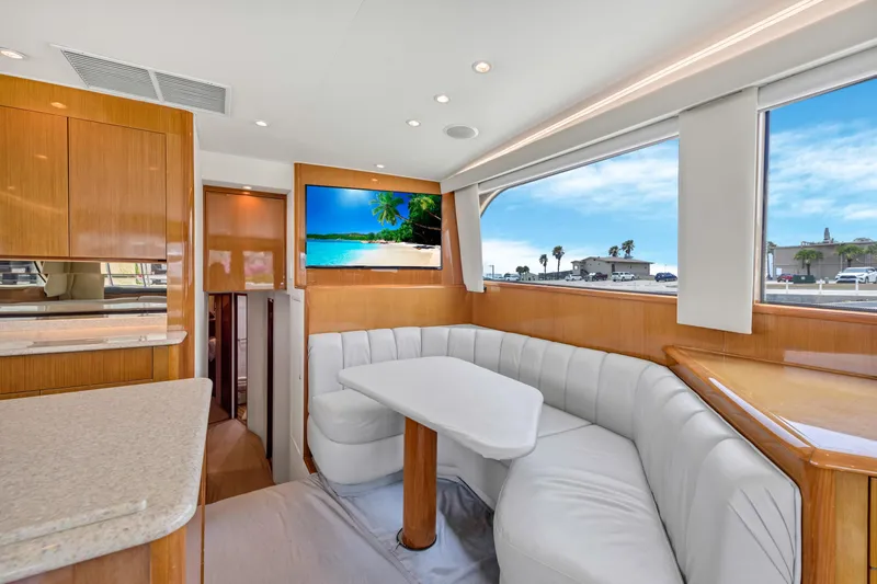 Slide: The Image of Interior of 2001 Viking 55 Convertible yacht with white leather seating and flat-screen TV. - 17