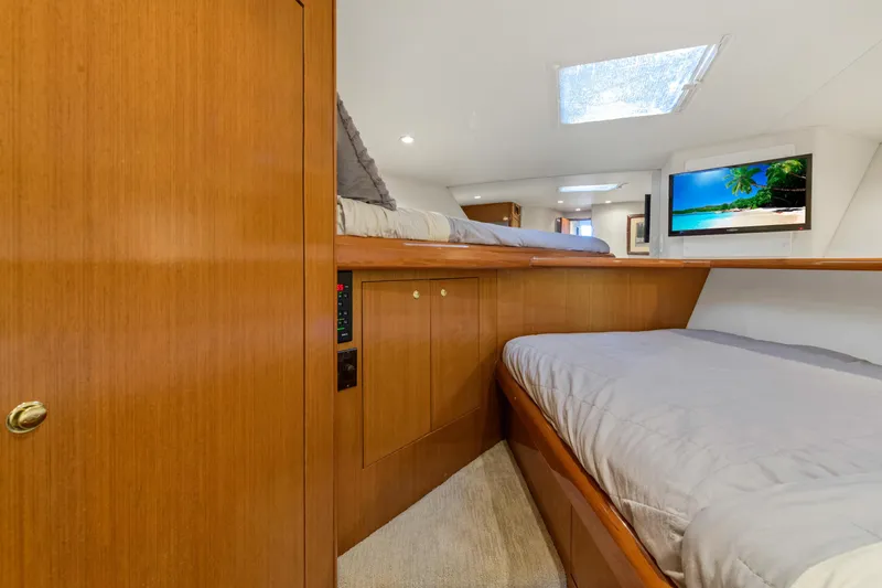 Slide: The Image of Interior cabin of 2001 Viking 55 Convertible yacht with wooden finishes and cozy bedding. - 28