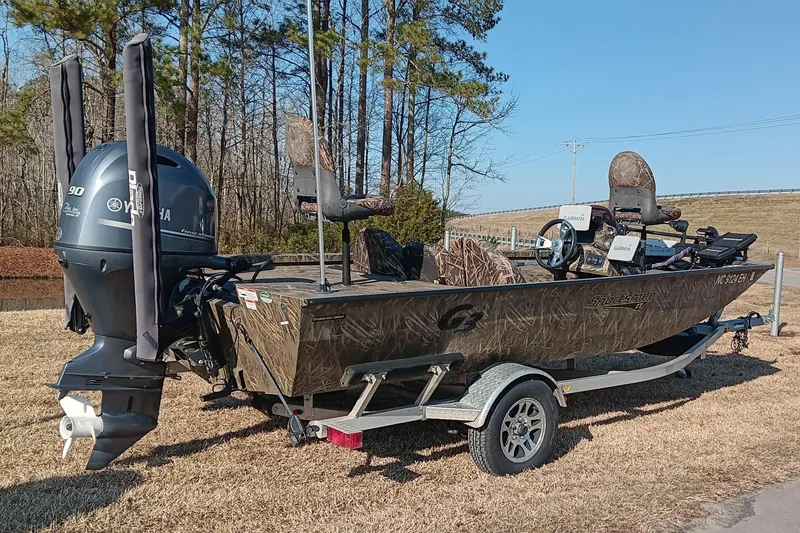 Slide: The Image of 2018 G3 Sportsman 17 Camo boat with Yamaha motor on trailer, outdoors. - 2