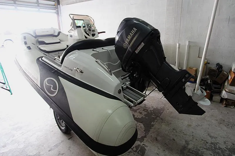 Slide: The Image of 2025 Walker Bay Venture 13 boat with Yamaha outboard motor in a garage. - 14