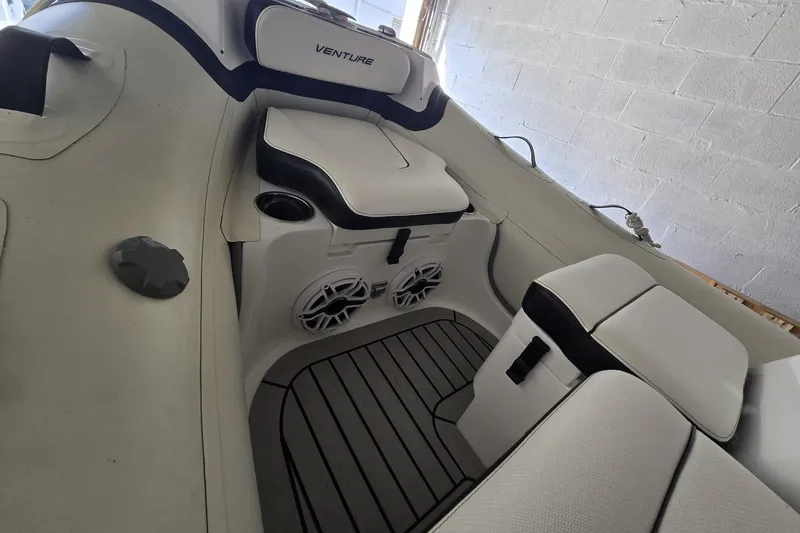 Slide: The Image of 2025 Walker Bay Venture 13 boat interior with cushioned seating and speakers. - 7