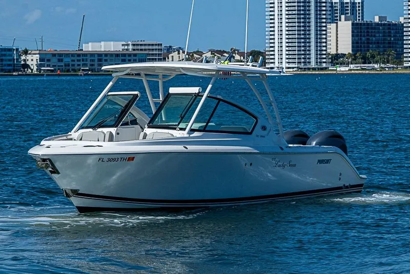 The Image of 2022 Pursuit DC 266 Dual Console boat cruising on water near city skyline. - 0