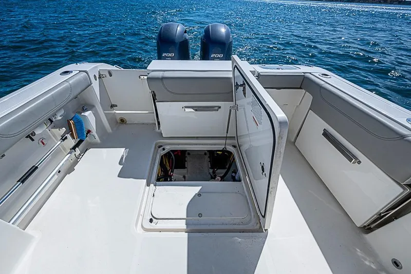 Slide: The Image of 2022 Pursuit DC 266 Dual Console boat with open storage compartments on the deck. - 10