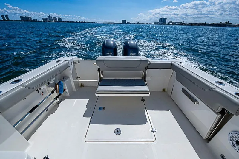Slide: The Image of 2022 Pursuit DC 266 Dual Console boat on open water, featuring spacious seating and twin engines. - 12