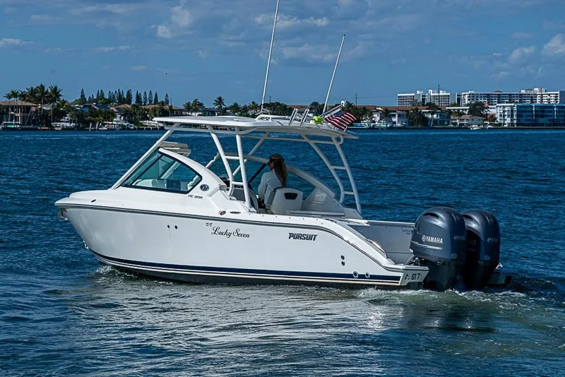 Slide: The Image of 2022 Pursuit DC 266 Dual Console boat cruising on a sunny day with twin Yamaha engines. - 26