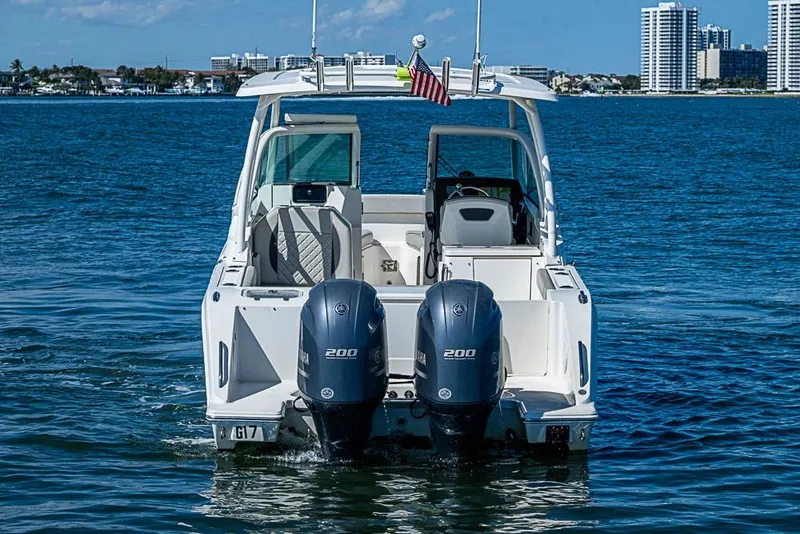 Slide: The Image of 2022 Pursuit DC 266 Dual Console boat on water with twin engines. - 28