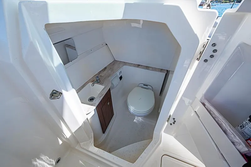 Slide: The Image of 2022 Pursuit DC 266 Dual Console boat interior with compact bathroom and sink. - 36