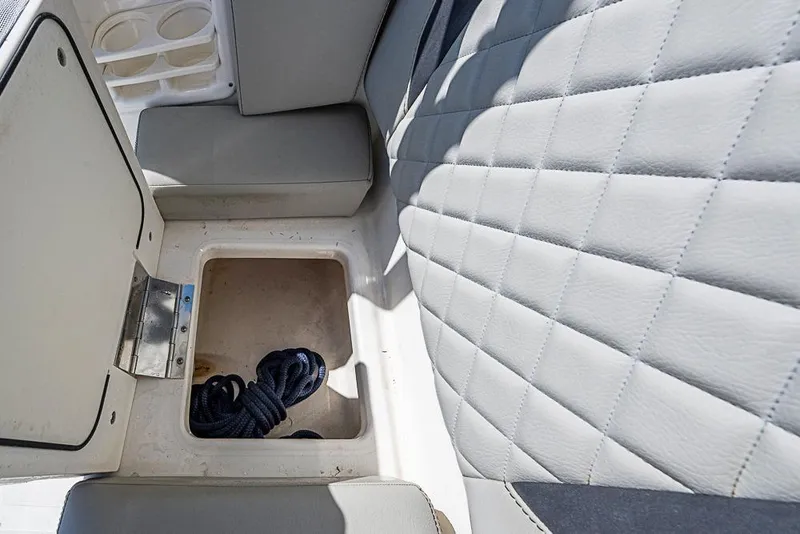 Slide: The Image of 2022 Pursuit DC 266 Dual Console boat storage compartment with coiled rope. - 37