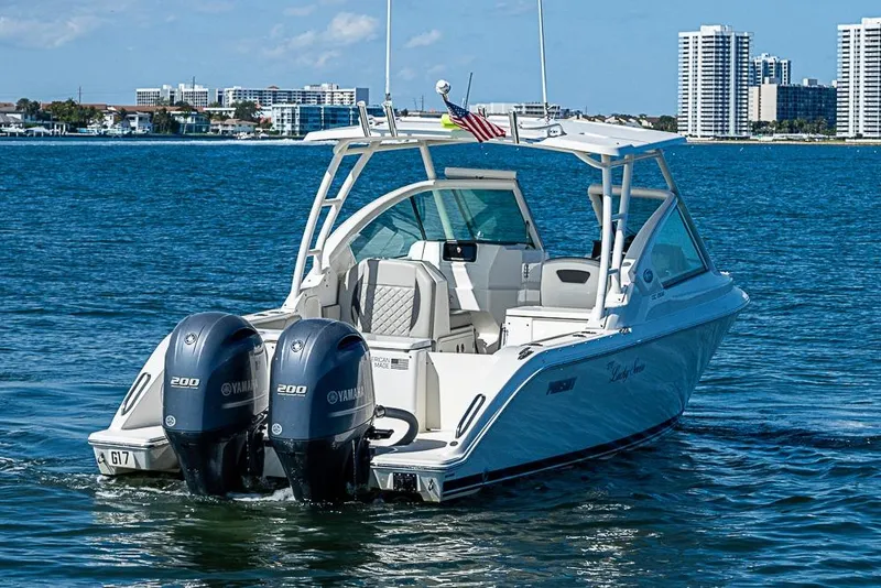 Slide: The Image of 2022 Pursuit DC 266 Dual Console boat on water with twin Yamaha engines. - 4