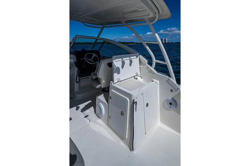 Slide: The Image of 2022 Pursuit DC 266 Dual Console boat interior with helm and sink, on open water. - 6