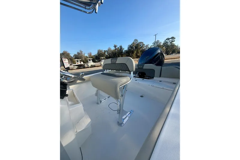 Slide: The Image of 2026 Key West 203 FS boat interior with seating and motor, under clear blue sky. - 10