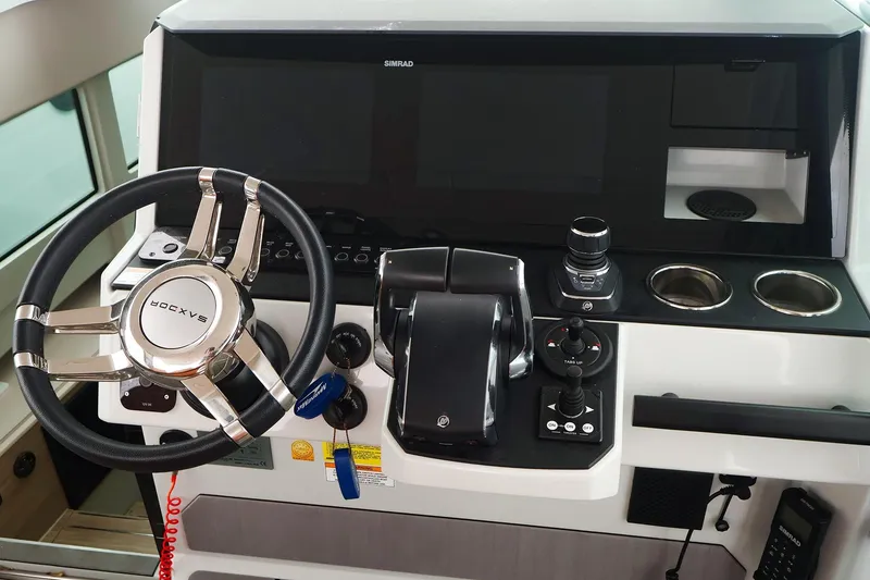 Slide: The Image of 2023 Saxdor 320 GTO helm with steering wheel, controls, and Simrad display. - 13