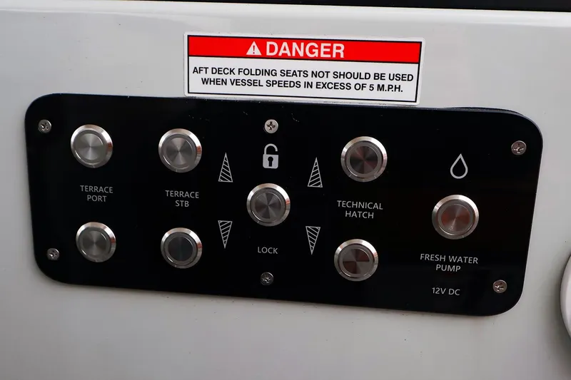 Slide: The Image of Control panel on 2023 Saxdor 320 GTO boat with warning label and various buttons. - 14