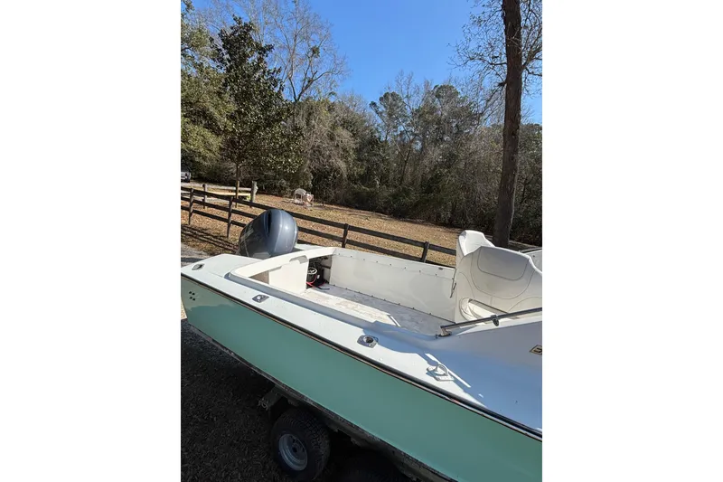 Slide: The Image of 1965 Bertram 20 Bahia Mar boat with Yamaha engine, parked outdoors near a house. - 8
