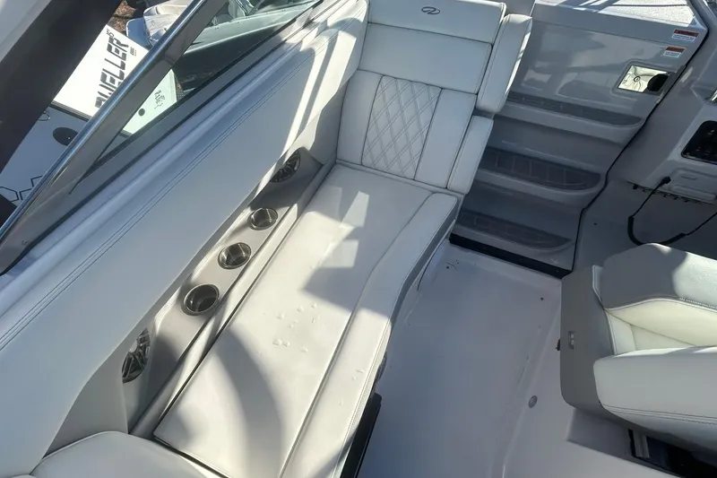 Slide: The Image of 2024 Regal 28 Express boat interior with white seating and cup holders. - 32