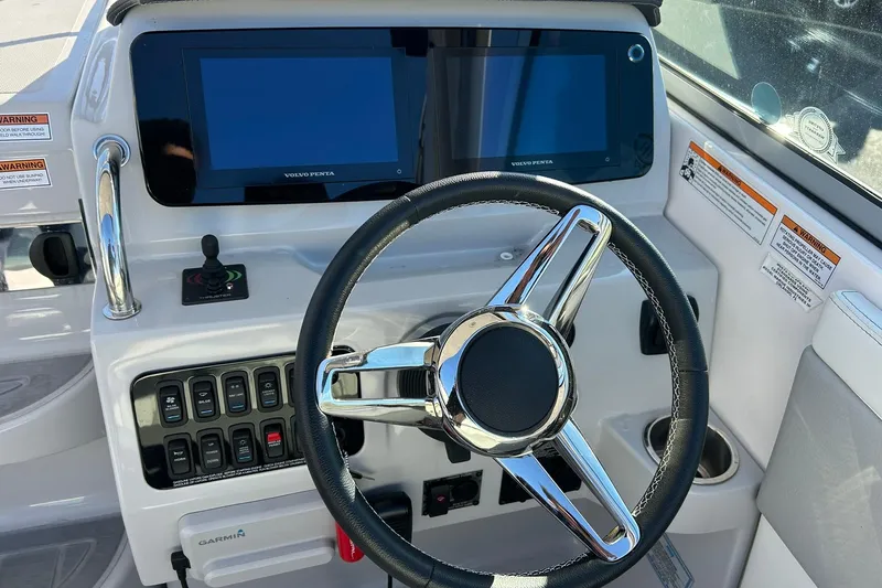 Slide: The Image of 2024 Regal 28 Express boat dashboard with steering wheel and dual displays. - 34