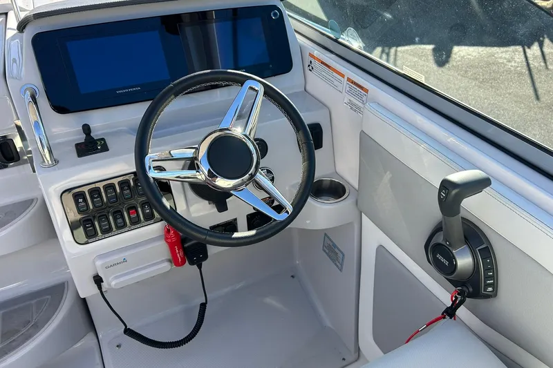 Slide: The Image of 2024 Regal 28 Express boat helm with steering wheel and control panel. - 35