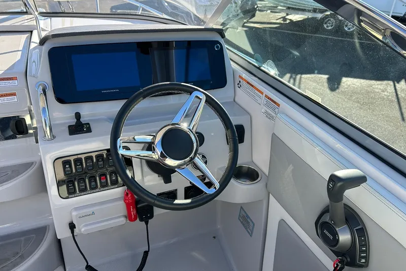 Slide: The Image of 2024 Regal 28 Express boat helm with steering wheel, controls, and navigation display. - 36