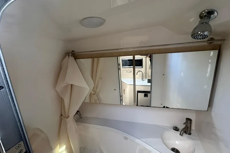 Slide: The Image of 2024 Regal 28 Express bathroom with mirror, sink, and showerhead. - 40