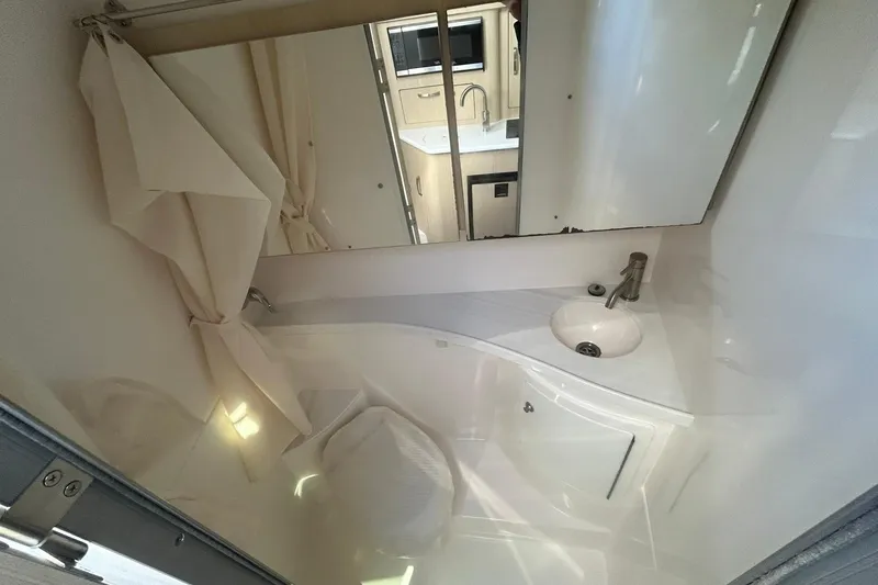 Slide: The Image of 2024 Regal 28 Express bathroom with sink, mirror, and shower curtain. - 42